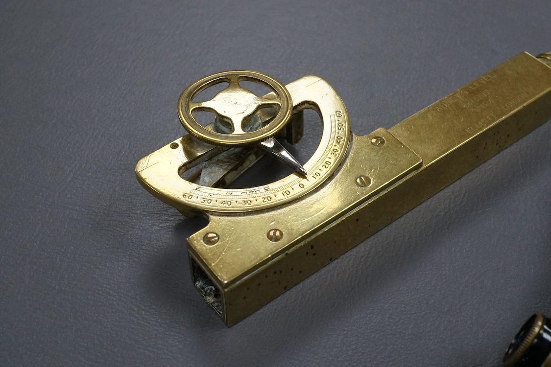 A brass Abney’s level by Elliott, London, 12cm long, together with a pair of folding brass miniature binoculars, 10cm wide.